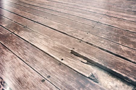 Damaged wood deck boards requiring structural repair and restoration